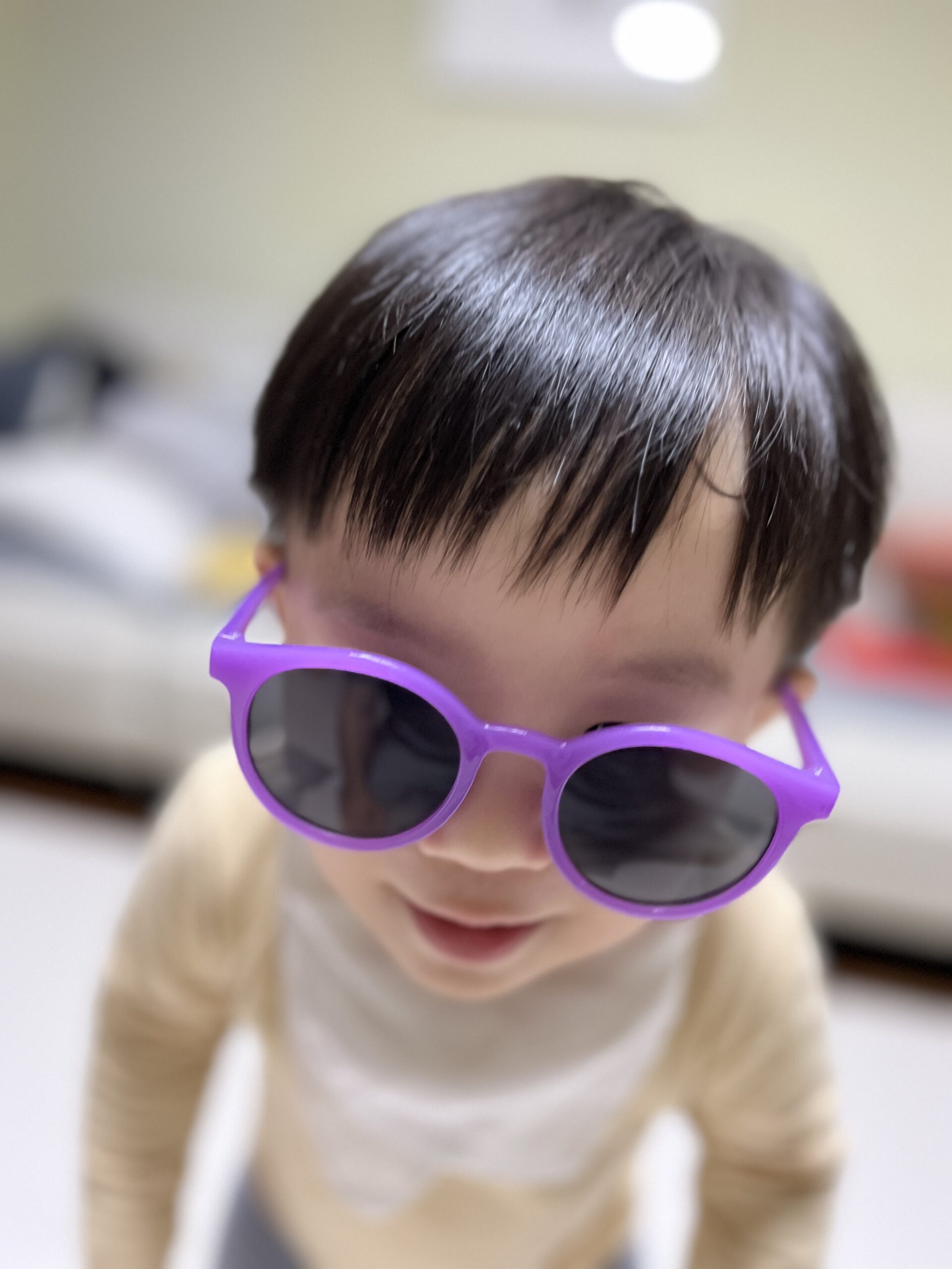 보라색 선글라스를 쓴 지호의 얼굴이 클로즈업되어 있다. 지호는 아래를 내려다보고 있으며, 선글라스가 얼굴에 비해 크게 느껴져 귀여운 모습이다.